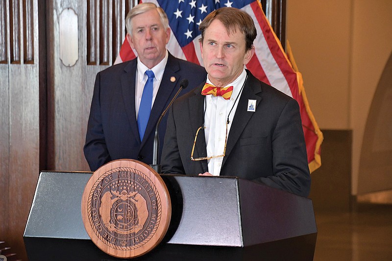 Dr. Randall Williams, director of the Missouri Department of Health and Senior Services, speaks Monday, April 13, 2020, during a COVID-19 news briefing as Gov. Mike Parson looks on.