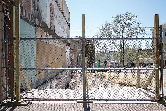 Fencing divides the sidewalk from the site where the building at 200 E. High St. once was. High and Madison streets have reopened after the demolition a couple weeks ago. The fate of what is now an empty lot at 200 E. High St. is unclear. 