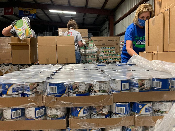 Tammy Waters and a team of other Domtar Ashdown plant employees packs boxes of food Tuesday, April 21, 2020, at Harvest Texarkana Regional Food Bank. Food will be distributed to residents in the 10-county area either through food trucks or local pantries. The need for food has increased because people have lost their jobs during the COVID-19 pandemic. Staff photo by Lori Dunn