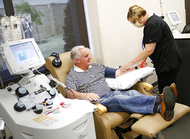 Phlebotomist Tamara Mosley, right, prepares Oklahoma State Sen. Paul Rosino to donate convalescent plasma at the Oklahoma Blood Institute in Oklahoma City, Thursday, April 16, 2020. Rosino tested positive for the new coronavirus in March and has since recovered. OBI has created a statewide registry to collect plasma from recovered patients for an experimental initiative to treat people suffering from severe symptoms of COVID-19.