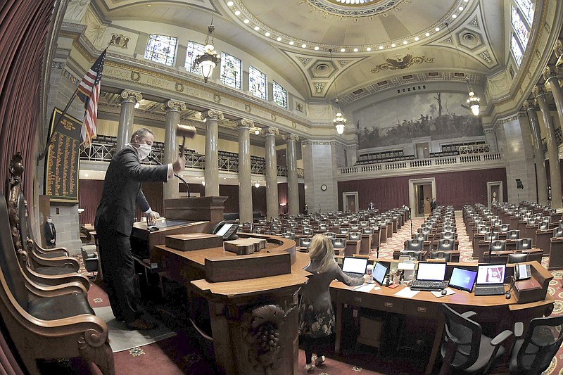 This April 8, 2020 file photo Missouri House Speaker Elijah Haahr wears a protective mask as he lowers the gavel in a nearly empty chamber to open the session in Jefferson City, Missouri. (Tim Bommel/Missouri House of Representatives via AP)