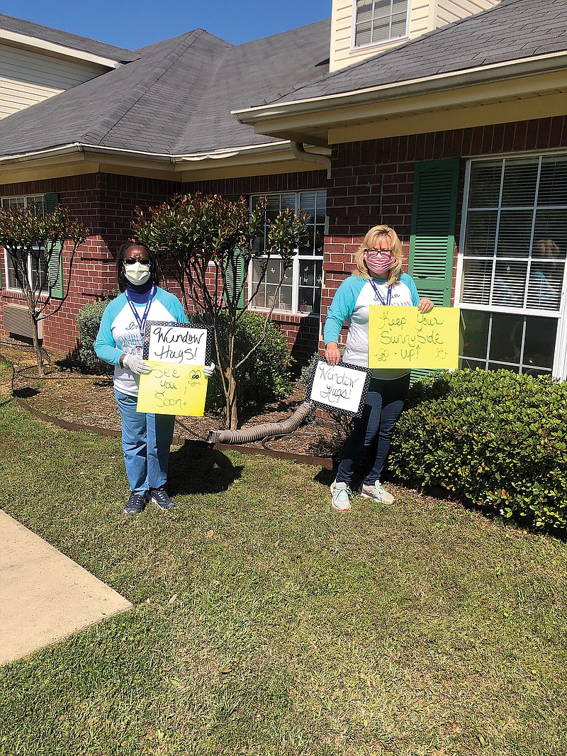 Kim Palmore and Vanessa Conway show off posters they made to entertain local nursing home and assisted living residents. Palmore and Conway are staff ombudsmen with the Ark-Tex Council of Governments' Area Agency on Aging.