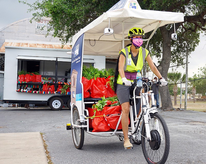 Brownsville Pedicab pilot Shelly Patterson rolls along as Brownsville Pedicab helps deliver fresh produce bags to vulnerable neighbors April 2 in the downtown Brownsville, Texas, area.