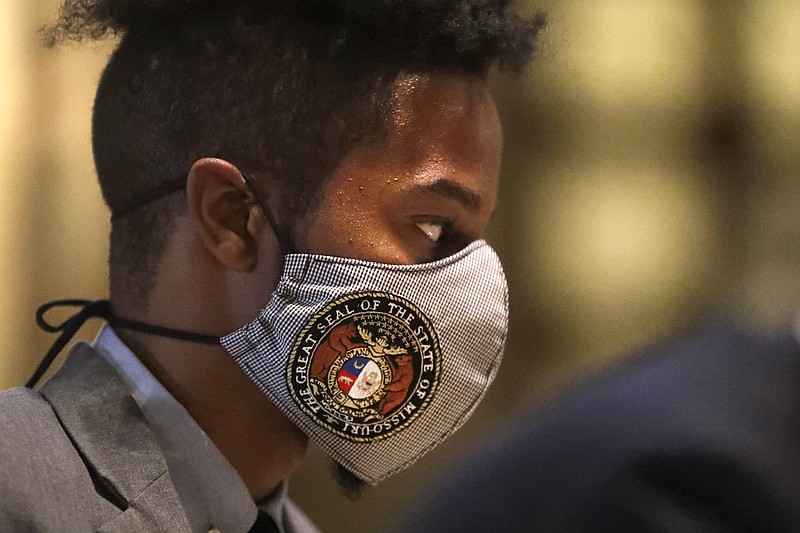 State Rep. Rasheen Aldridge, D-St. Louis, wears a protective mask adorned with the Missouri state seal while standing outside the House chamber Monday, April 27, 2020, in Jefferson City, Mo. Members of the House returned to the Capitol Monday to begin debate on the budget for the upcoming fiscal year, a daunting task amid declining revenue because of the coronavirus. (AP Photo/Jeff Roberson)