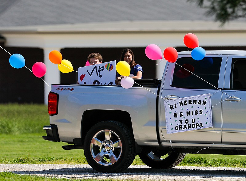 Liv Paggiarino/News Tribune

Family members sit in the back of a pick up truck as they greet the seniors of StoneBridge Senior Living on Saturday in Westphalia. The parade started at around 3 p.m., but there were cars arriving to line up down the street as early at 1:45 p.m. or so. 