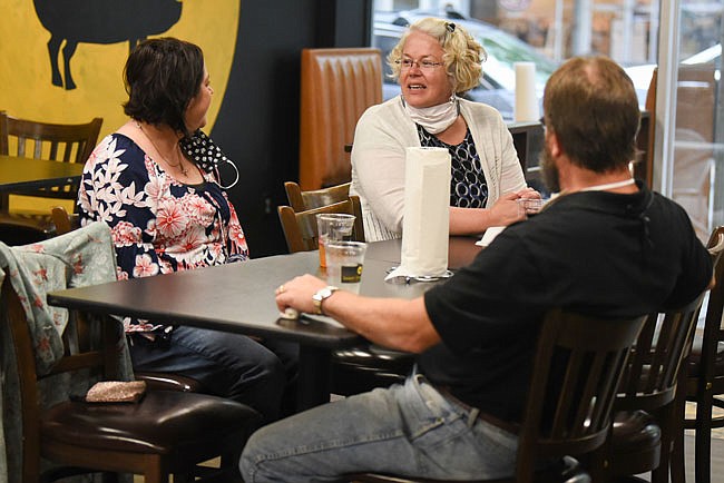 From left, Michelle Caban, Colleen Foster and Jeff Falter chat about how their friends and co-workers will cope with the state reopening on Monday, May 4, 2020, at Sweet Smoke BBQ in Jefferson City. Three tables at Sweet Smoke BBQ were occupied during the lunch hour in addition to a few people ordering carryout.