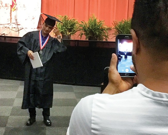 Texas High School graduate Francisco Antonio Alvarado Prieto moves his tassel over Monday to indicate he has graduated as a family member captures the moment. 'We are honored to be able to do this in this way  because we know our seniors are missing out on so much," said Paul Norton, TISD superintendent.
