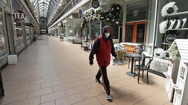 A man walks through the 5th Street Arcade, a selection of indoor shops closed during the pandemic, Thursday, May 7, 2020, in Cleveland. (AP Photo/Tony Dejak)