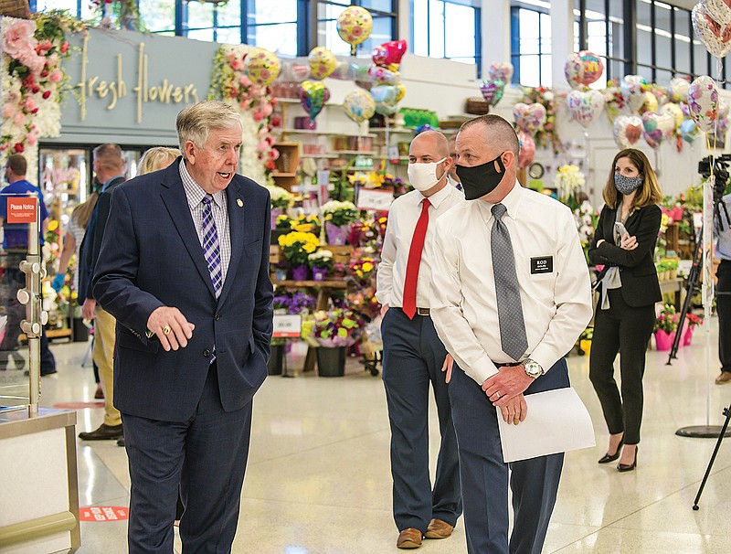 Gov. Mike Parson, left, visits with Jefferson City Hy-Vee store director Rod Dolph, right, and assistant store director Darrick Sigwerth, background, Thursday during a visit to the west-side grocery store. The governor and first lady Teresa Parson visited with management while touring the store to see how they have handled multiple aspects of business during this pandemic.