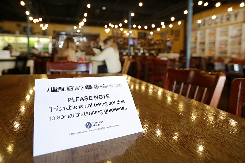 In this April 27, 2020, file photo, a sign marks a table not to be used at Puckett's Grocery & Restaurant in Franklin, Tenn. As more businesses like department stores and restaurants reopen, tensions are expected to rise even more between workers and customers at a time when labor groups say there hasn't been enough training. (AP Photo/Mark Humphrey, File)