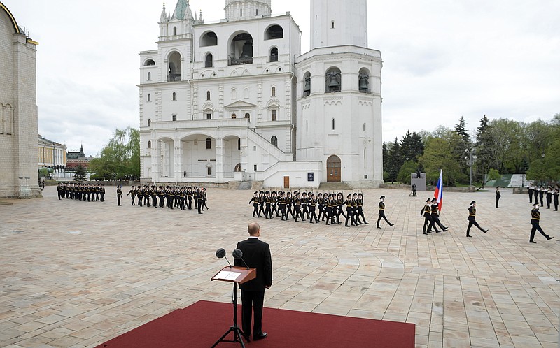 Russian President Vladimir Putin, back to a camera, watches the honour guard of the Presidential Regiment march on Cathedral Square in the Kremlin marking the 75th anniversary of the Nazi defeat in World War II in Moscow, Russia, Saturday, May 9, 2020. Putin cancelled a massive Victory Day marking the 75th anniversary of the Nazi defeat in World War II but ordered a flyby of warplanes over Red Square. (Alexei Druzhinin, Sputnik, Kremlin Pool Photo via AP)
