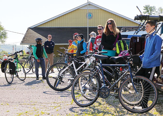 Cyclists stand Saturday, May 9, 2020, by their bikes and vehicles, listening to instructor David Bange outline the route for the morning's community bike ride in north Jefferson City. More than 50 cyclists of all ages showed up.