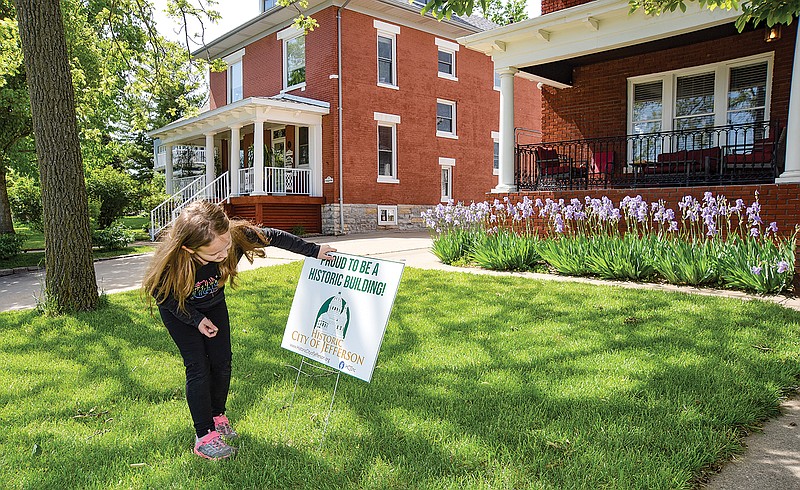 Historic City of Jefferson Executive Director Anne Green had help Thursday in the form of her 7-year-old daughter Vivien, who helped her place signs in front of multiple locations in the 700 block of East Capitol Avenue. May is Historic Preservation Month and to draw attention to some of those properties, Green is placing signs in the front lawn of the home or business.