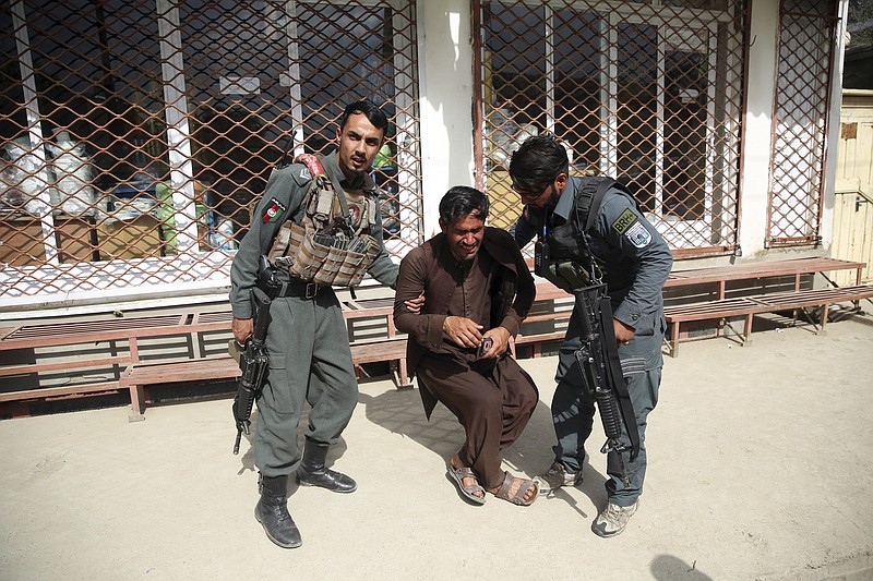 Afghan policemen comfort a man after an attack on a maternity hospital, in Kabul, Afghanistan, Tuesday, May 12, 2020. Militants stormed a maternity hospital in the western part of Kabul on Tuesday, setting off an hours-long shootout with the police and killing over a dozen people, including two newborn babies, their mothers and an unspecified number of nurses (AP Photo/Rahmat Gul)