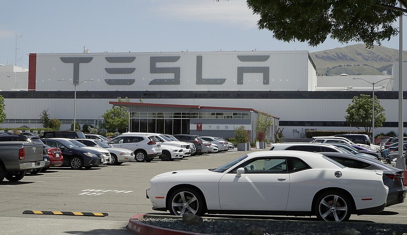 Vehicles are seen parked at the Tesla car plant Monday, May 11, 2020, in Fremont, Calif. The parking lot was nearly full at Tesla's California electric car factory Monday, an indication that the company could be resuming production in defiance of an order from county health authorities. (AP Photo/Ben Margot)