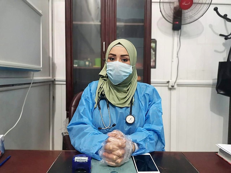 This May 13, 2020, picture provided by Dr. Marwa al-Khafaji shows the doctor back at work after 20 days in isolation after she tested positive for the coronavirus at a hospital in Karbala, Iraq. Dr. Marwa al-Khafaji’s homecoming from a hospital isolation ward was tainted by spite. Someone had barricaded her family home’s gate with a concrete block.  The message from the neighbors was clear: She had survived coronavirus, but the stigma of having had the disease would be a more pernicious fight. (AP Photo)