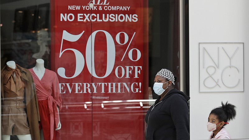 A woman walks with a child at SouthPark Mall, Wednesday, May 13, 2020, in Strongsville, Ohio. Ohio retail businesses reopened Tuesday following a nearly two-month-long shutdown ordered by Gov. Mike DeWine to limit the spread of the coronavirus. (AP Photo/Tony Dejak)