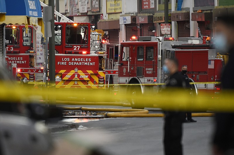 Los Angeles Police Department officers work the scene of a structure fire that injured multiple firefighters, according to a fire department spokesman, Saturday, May 16, 2020, in Los Angeles. (AP Photo/Mark J. Terrill)