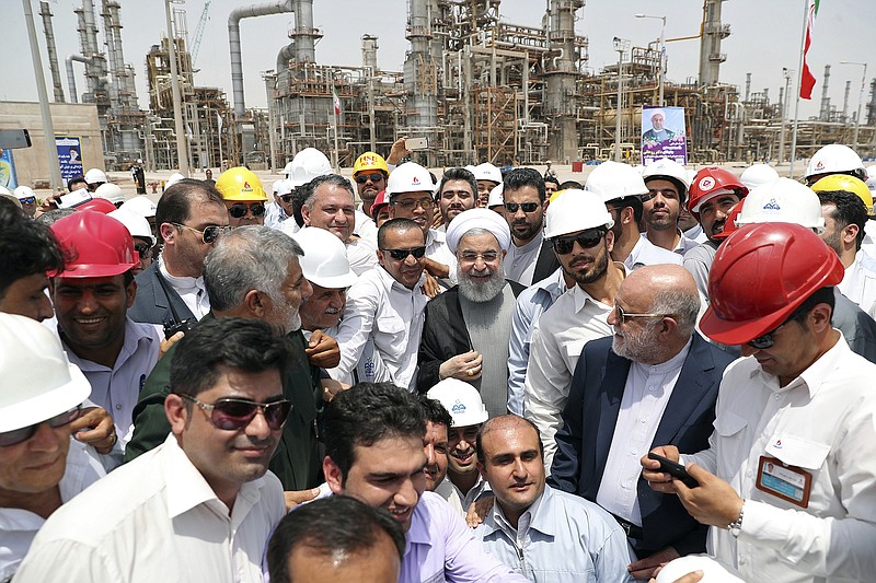 FILE - In this April 30, 2017 file photo, released by an official website of the office of the Iranian Presidency, Iranian President Hassan Rouhani, center, inaugurates the Persian Gulf Star Refinery in Bandar Abbas, Iran. Five Iranian tankers likely carrying at least $45.5 million worth of gasoline and similar products are now sailing to Venezuela as of Sunday, May 17, 2020, part of a wider deal between the two U.S.-sanctioned nations amid heightened tensions between Tehran and Washington. Analysts say the gasoline they carry came from the Persian Gulf Star Refinery. (Iranian Presidency Office via AP, File)