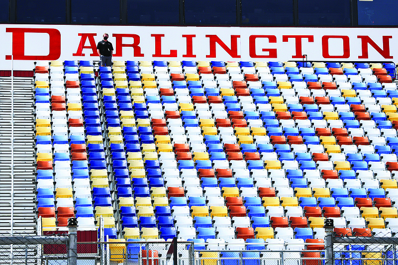 A man stands in an otherwise empty grandstand at Darlington Raceway before the Real Heroes 400 NASCAR Cup Series race Sunday in Darlington, S.C.