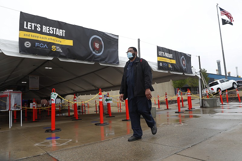 United Auto Workers members leave the Fiat Chrysler Automobiles Warren Truck Plant after the first work shift, Monday, May 18, 2020, in Warren, Mich. Fiat Chrysler Automobiles NV along with rivals Ford and General Motors Co., restarted the assembly lines on Monday after several week of inactivity due to the corona virus pandemic. (AP Photo/Paul Sancya)