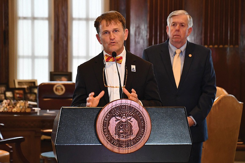 Dr. Randall Williams, director of the Missouri Department of Health and Senior Services, speaks Monday during a COVID-19 briefing as Gov. Mike Parson looks on.