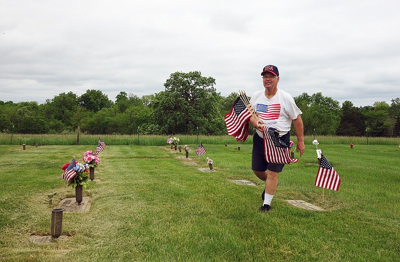 David Beaver, of American Legion Post 210, places flags at the graves of veterans buried at Callaway Memorial Gardens in honor of Memorial Day. 