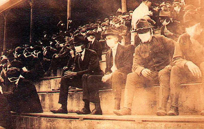 This undated photo provided by Georgia Tech alumnus Andy McNeil shows a Georgia Tech home football game during the 1918 season. The photo was taken by Georgia Tech student Thomas Carter. The 102-year-old photo could provide a snapshot of sports once live games resume: Fans packed in a campus stadium in the midst of a pandemic wearing masks with a smidge of social distance between them on concrete seats. 