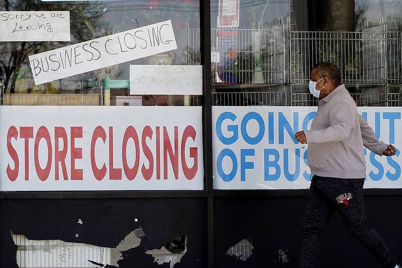 A man looks at signs of a closed store due to COVID-19 in Niles, Ill., Thursday, May 21, 2020. More than 2.4 million people applied for U.S. unemployment benefits last week in the latest wave of layoffs from the viral outbreak that triggered widespread business shutdowns two months ago and sent to economy into a deep recession. (AP Photo/Nam Y. Huh)