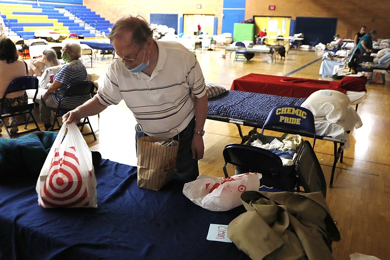 Dan Roberts packs his belongings as he prepares to move out at the temporary shelter at Midland High School, Thursday, May 21, 2020, in Midland, Mich. Roberts, a resident at Riverside Place Senior Living Community was forced out of the complex due to rising floodwaters of the Tittabawassee River. People living along two mid-Michigan lakes and parts of a river have were evacuated following several days of heavy rain that produced flooding and put pressure on dams in the area. (AP Photo/Carlos Osorio)