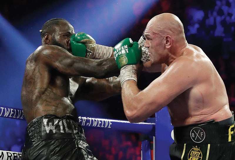 Tyson Fury (right) lands a right to Deontay Wilder during a WBC heavyweight championship boxing match Feb. 22 in Las Vegas. Boxing promoter Bob Arum said he plans to stage a card of five fights June 9 at the MGM Grand.