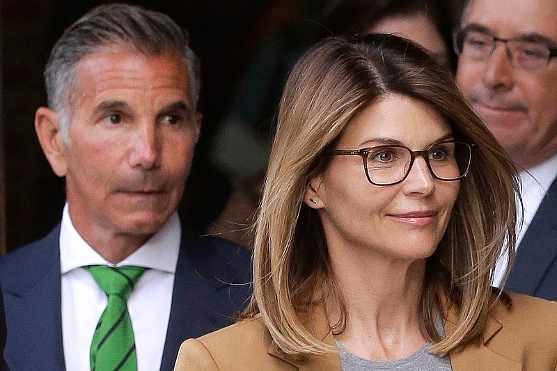 In this April 3, 2019, file photo, actress Lori Loughlin, front, and her husband, clothing designer Mossimo Giannulli, left, depart federal court in Boston after a hearing in a nationwide college admissions bribery scandal. On Thursday, May 21, 2020, the U.S. Attorney's Office in Boston said Loughlin and Giannulli have agreed to plead guilty to charges of trying to secure the fraudulent admission of their two children to the University of Southern California as purported athletic recruits. (AP Photo/Steven Senne, File)