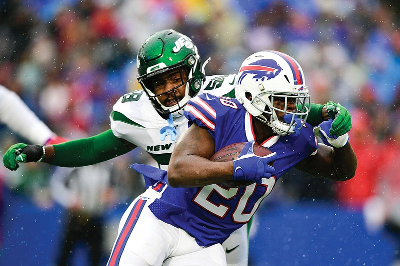 In this Dec. 29, 2019, file photo, Bills running back Frank Gore runs past Jets linebacker James Burgess during a game in Orchard Park, N.Y. Gore signed a one-year contract with the Jets.