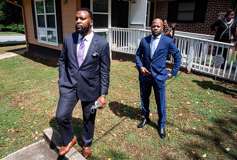 Lee Merritt, left, and Chris Stewart, attorneys for the mother of Ahmaud Arbery, are seen at a news conference on Wednesday, May 19, 2020, in East Point, Georgia. The attorneys appeared and spoke at a news conference held by the Atlanta branch of the NAACP. After a video of the shooting of Arbery emerged on social media, the Georgia Bureau of Investigation, arrested Gregory McMichael, 64, and his son, Travis McMichael, 34, and they were jailed on murder and aggravated assault charges. (AP Photo/Ron Harris)