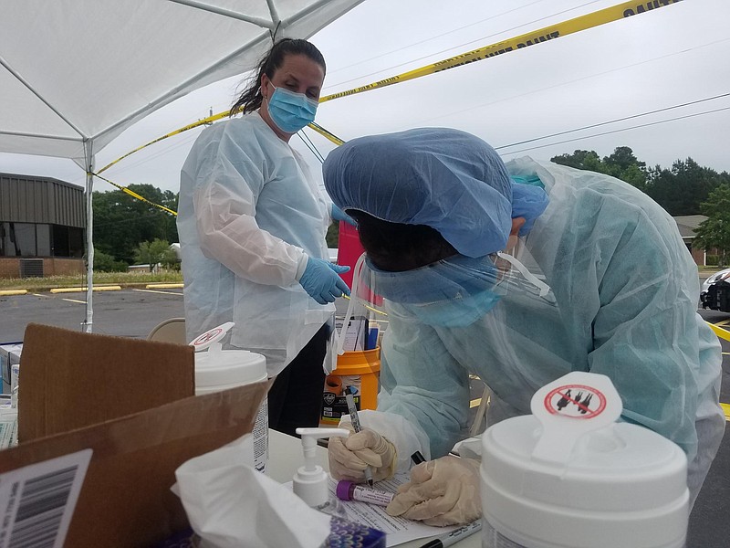 Staff from Healthy Connections, Inc. work at a one-day, pop-up, COVID-19 testing event held May 21, 2020, at the old De Queen Medical Center parking lot in De Queen, Ark. Wearing personal protective equipment, five employees collected tests from 10 a.m. to 2 p.m. at no cost to people tested. People could drive up and be tested, no matter their symptoms. The Mena, Arkansas-based community health center will hold another testing event in De Queen on June 11 and then again the next day, June 12, in Nashville, Ark.