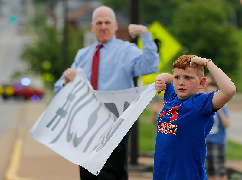 Liv Paggiarino/News Tribune

Blake Welch, 10, holds up his arms while holding a banner that reads, "#JCStrong" on Friday in front of the John G. Christy Municipal Building. The Care-A-Van passed by the building twice in its loop around downtown Jefferson City. 