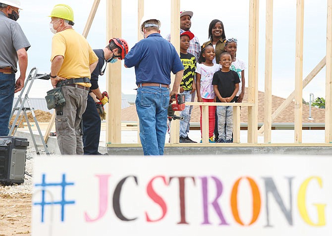 The Harrison family stands together for a photo Friday during the Raising of the Wall ceremony for a house being constructed by Habitat for Humanity in the aftermath of the tornado.