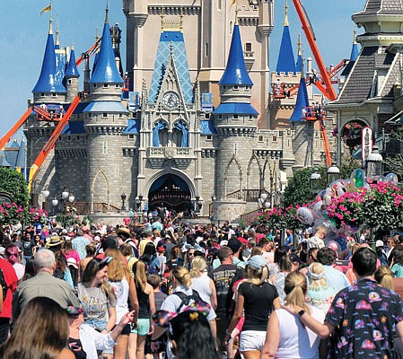 In this March 12 file photo, a crowd is shown along Main Street USA in front of Cinderella Castle in the Magic Kingdom at Walt Disney World in Lake Buena Vista, Fla.