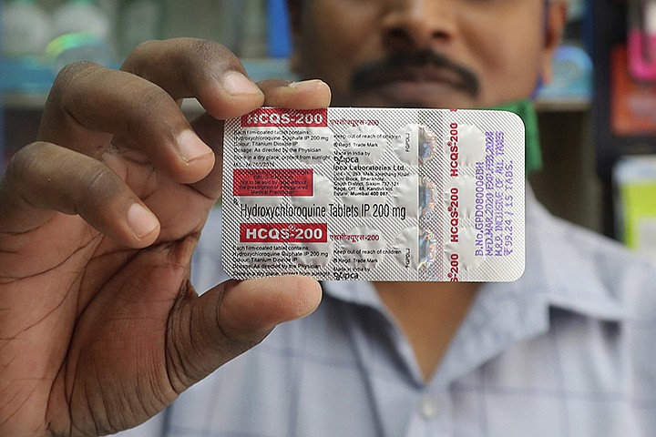 In this Tuesday, May 19, 2020 file photo, a chemist holds a pack of hydroxychloroquine tablets in Mumbai, India. A Friday, May 22, 2029 report in the journal Lancet shows malaria drugs pushed by U.S. President Donald Trump as treatments for the coronavirus not only did not help but were tied to a greater risk of death and heart rhythm problems in a study of nearly 100,000 patients around the world. (AP Photo/Rafiq Maqbool)