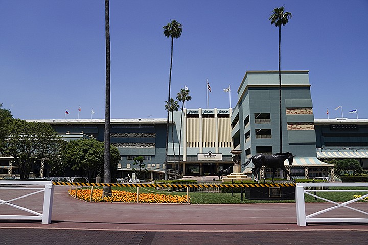 In this Friday, May 22, 2020 photo, the grounds  sit empty of fans during a day of horse racing at Santa Anita Park in Arcadia, Calif. Horse racing returned to the track after being idled for one and a half months because of public health officials' concerns about the coronavirus pandemic. (AP Photo/Ashley Landis)