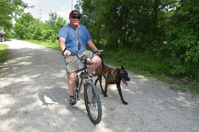 Gerry Tritz/News Tribune
Holts Summit resident Jack Jones walks Tigger, his dutch malinois, Sunday morning on the Katy Trail in North Jefferson City.