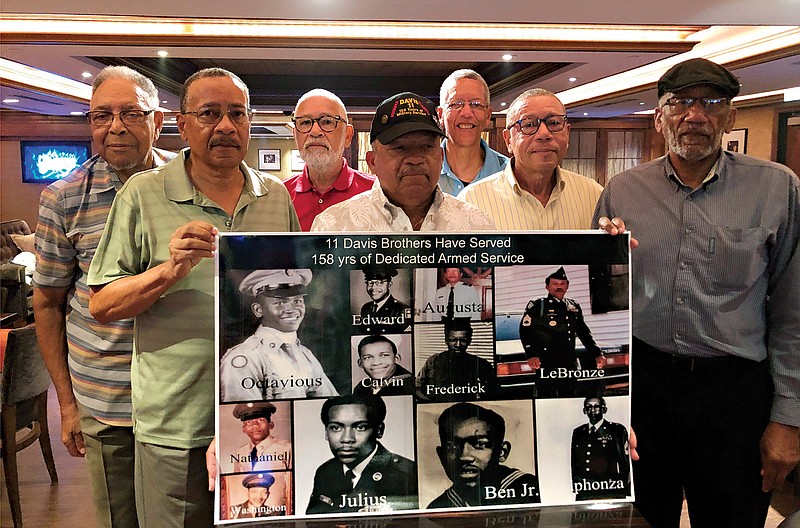 In this July 12, 2019, file photo, from left, Eddie Davis and his brothers Julius, Octavious, Lebronze, Frederick, Arguster and Nathaniel pose for a photo behind a family picture during a reunion at a hotel-casino in Tunica, Miss. Combined, the 11 brothers would go on to serve 158 years in the armed forces. Ben Davis Jr., seen in the photo collage second from right, died in April at the age of 94 after contracting COVID-19 at the Bill Nichols State Veterans Home in Alexander City, Ala., his step-grandson said.