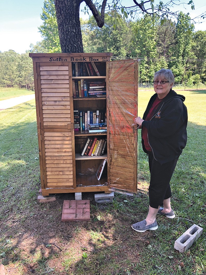 Bobbie Smith stands by a large, weatherproof small library she helped set up on a Nevada Country road.