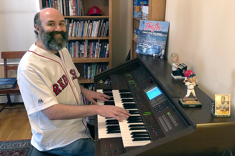 In this April 2020, photo provided by Josh Kantor, the Boston Red Sox organist plays the organ in his home in Cambridge, Mass. Each afternoon since what would have been opening day, Kantor has been live-streaming concerts of ballpark music and other fan requests from his home in an attempt to recreate the community feeling baseball fans might be missing while the sport is shut down during the coronavirus pandemic. (Mary Eaton/Josh Kantor via AP)