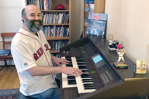 In this April  photo provided by Josh Kantor, the Red Sox organist plays the organ in his home in Cambridge, Mass.