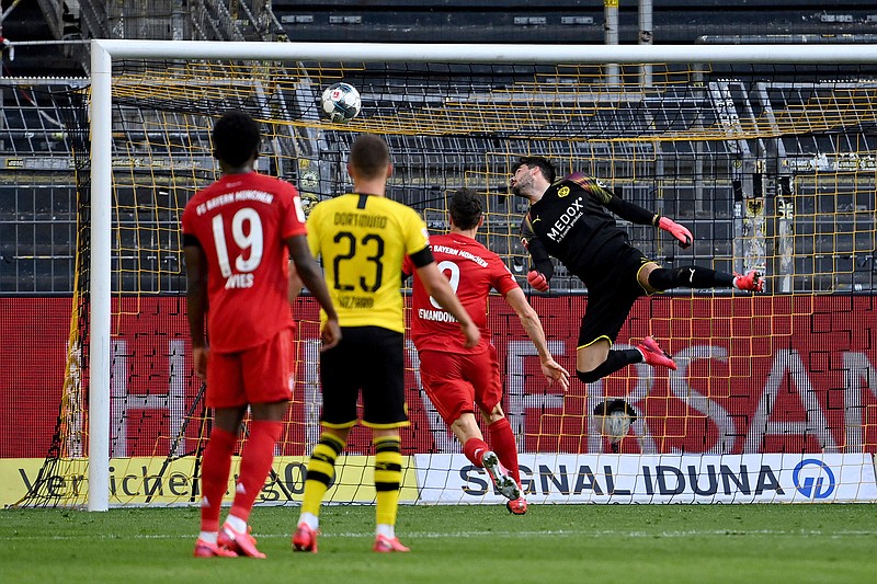 Dortmund's goalkeeper Roman Buerki, right, fails to safe a shot by Munich's Joshua Kimmich during the German Bundesliga soccer match between Borussia Dortmund and FC Bayern Munich in Dortmund, Germany, Tuesday, May 26, 2020. The German Bundesliga is the world's first major soccer league to resume after a two-month suspension because of the coronavirus pandemic. (Federico Gambarini/DPA via AP, Pool)