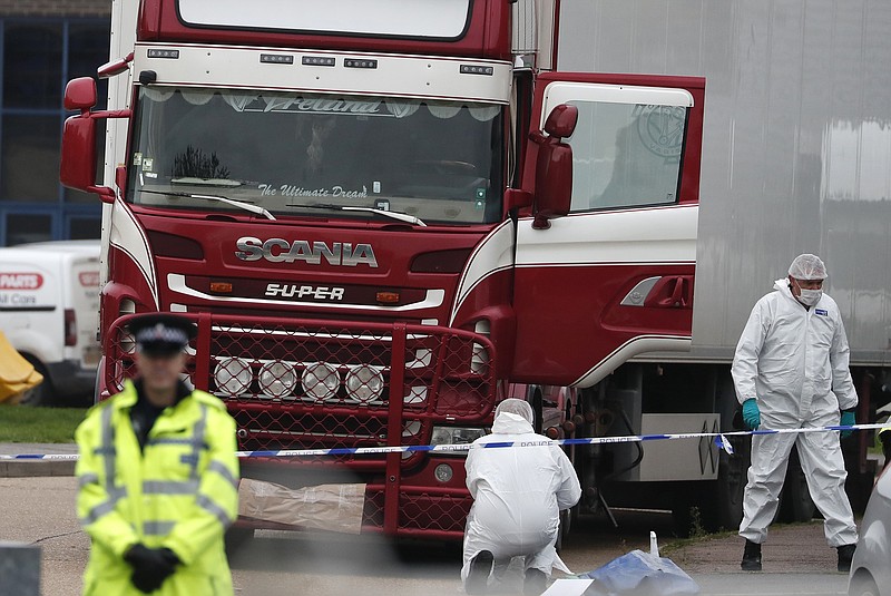 FILE - In this Wednesday Oct. 23, 2019 file photo, forensic police officers attend the scene after a truck was found to contain a large number of dead bodies, in Grays, South England. Police have arrested 26 people suspected of human trafficking during a large-scale operation in Belgium and France in relation to the death of the Vietnamese migrants whose bodies were found in a refrigerated truck in Britain last year. Judicial authorities said that a series of early Wednesday May 27, 2020 raids took place simultaneously in Belgium and France on Tuesday as part of two legal investigations (AP Photo/Alastair Grant, file)