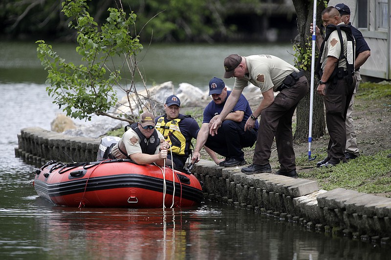 In this Tuesday, May 26, 2020, photo, emergency personnel dredge a pond at Shoreline Lakeside Apartments during their search for missing children Miracle Crook, 3, and Tony Crook, 2, in Tulsa, Okla. Searchers used sonar to examine the pond for the two young children last seen days ago with their noncustodial mother, who was arrested after being questioned about their disappearance. (Mike Simons/Tulsa World via AP)