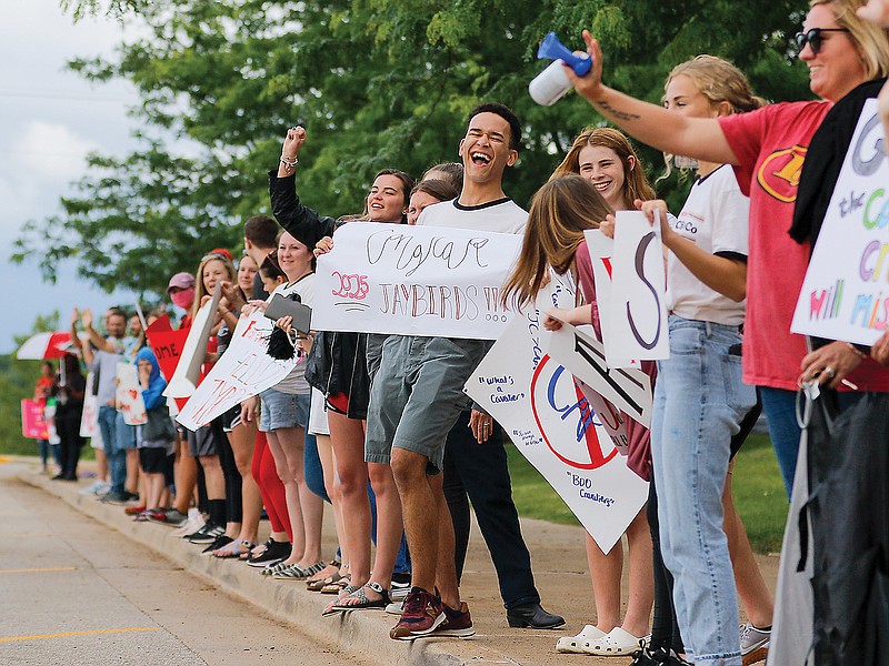 Maxwell Ntalamu, center, laughs with friends while cheering on the eighth-grade graduating class of 2020 at Lewis and Clark Middle School during a drive-thru promotion celebration Wednesday at the school. 