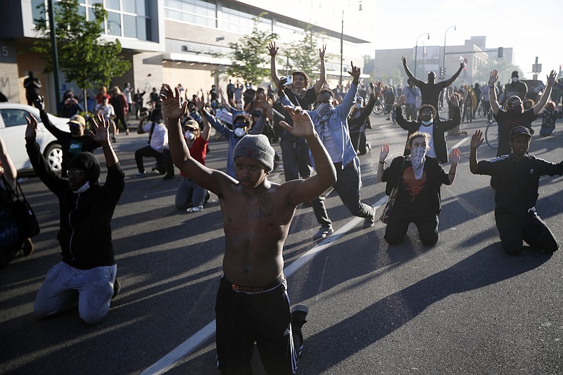 Demonstrators gather in the street with their hands raised Friday, May 29, 2020, in Minneapolis. Protests continued following the death of George Floyd, who died after being restrained by Minneapolis police officers on Memorial Day. (AP Photo/John Minchillo)